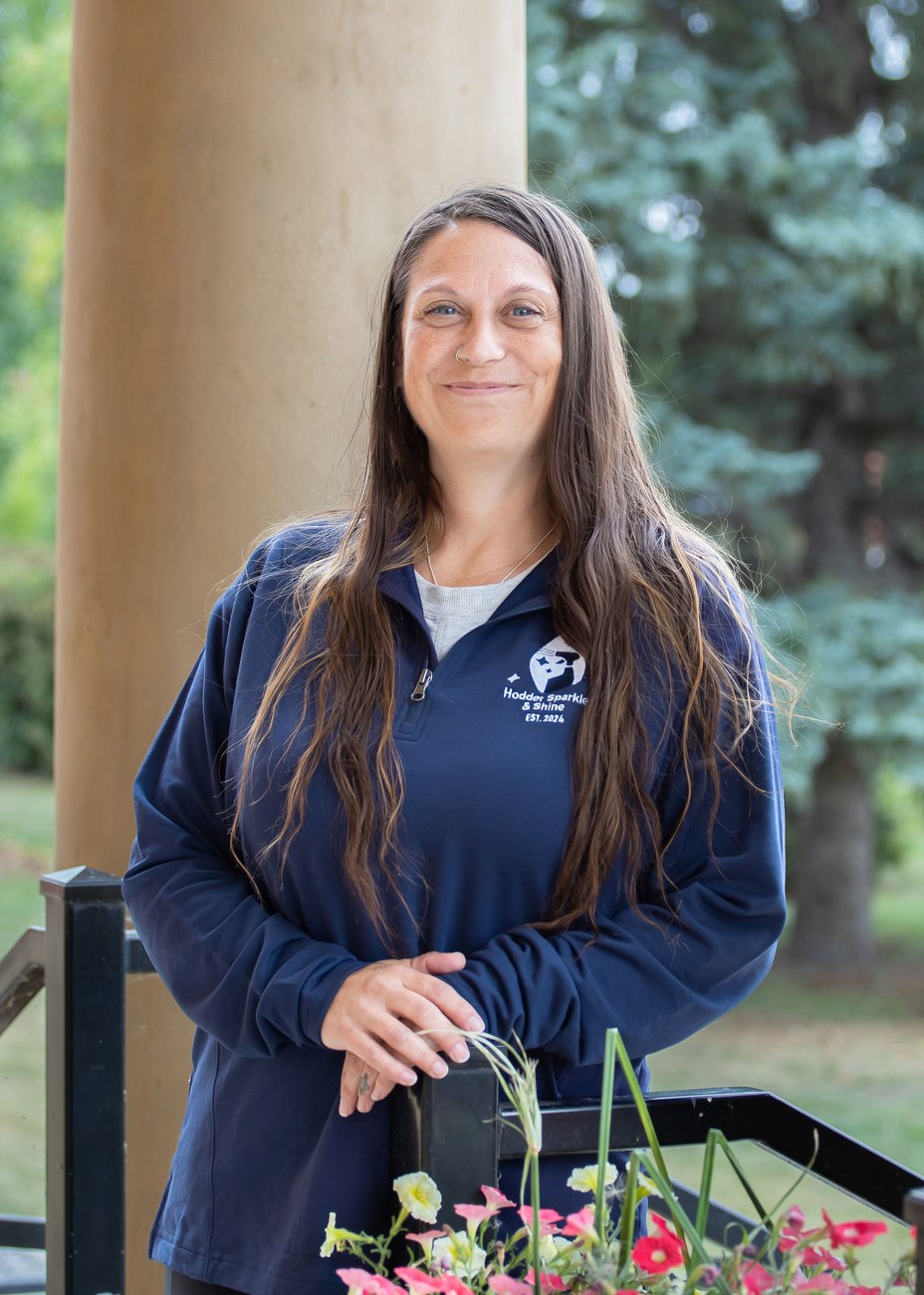 Marsha, Hodder Sparkle & Shine cleaner, smiling in her HSS quarter-zip