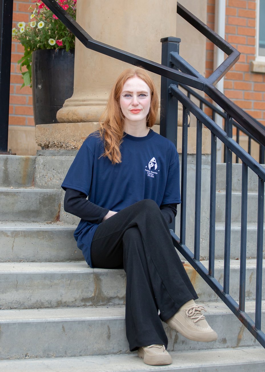 Zoey, Hodder Sparkle & Shine cleaner, sitting on steps in her HSS t-shirt